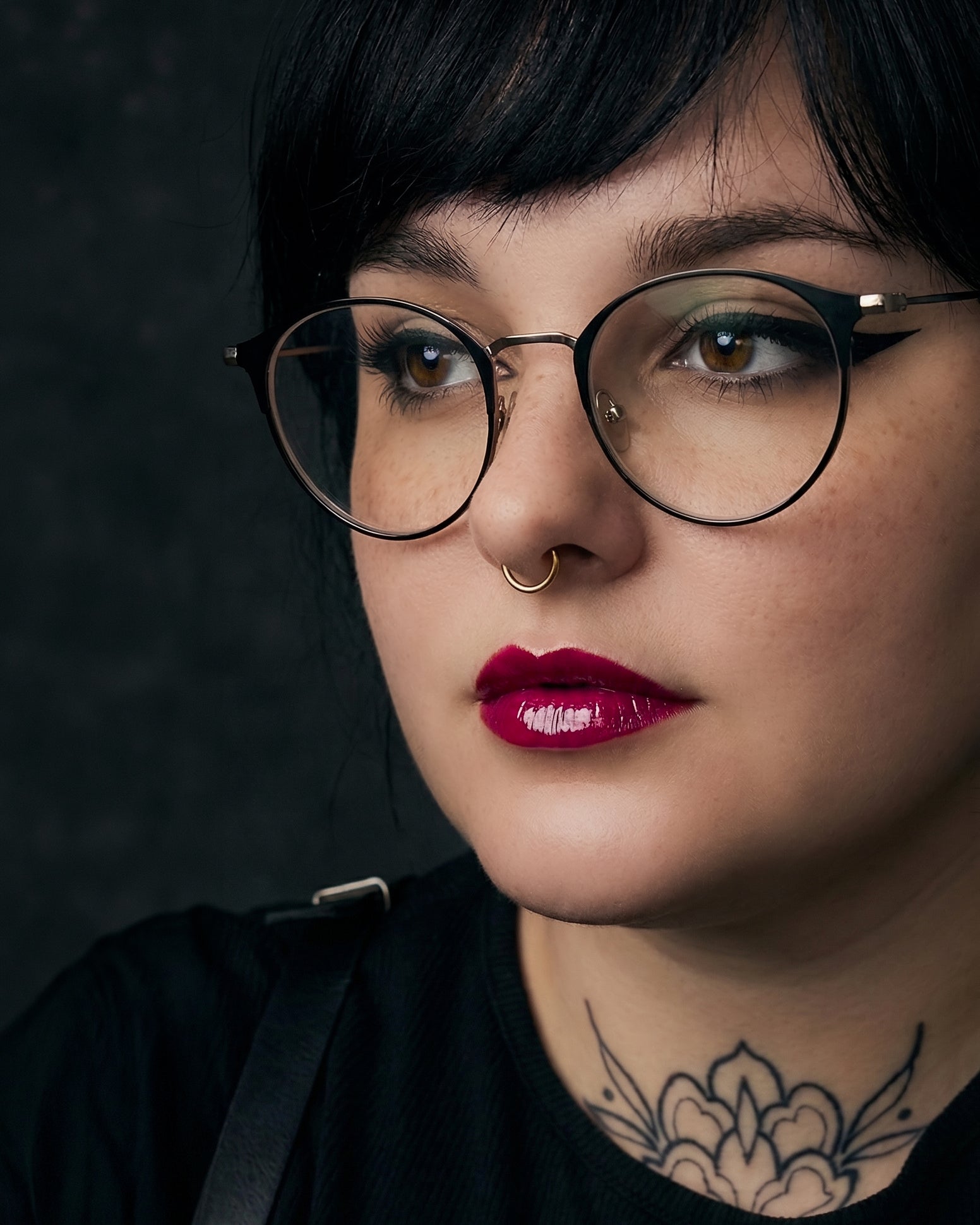 Close-up of a person wearing glasses with a dark background