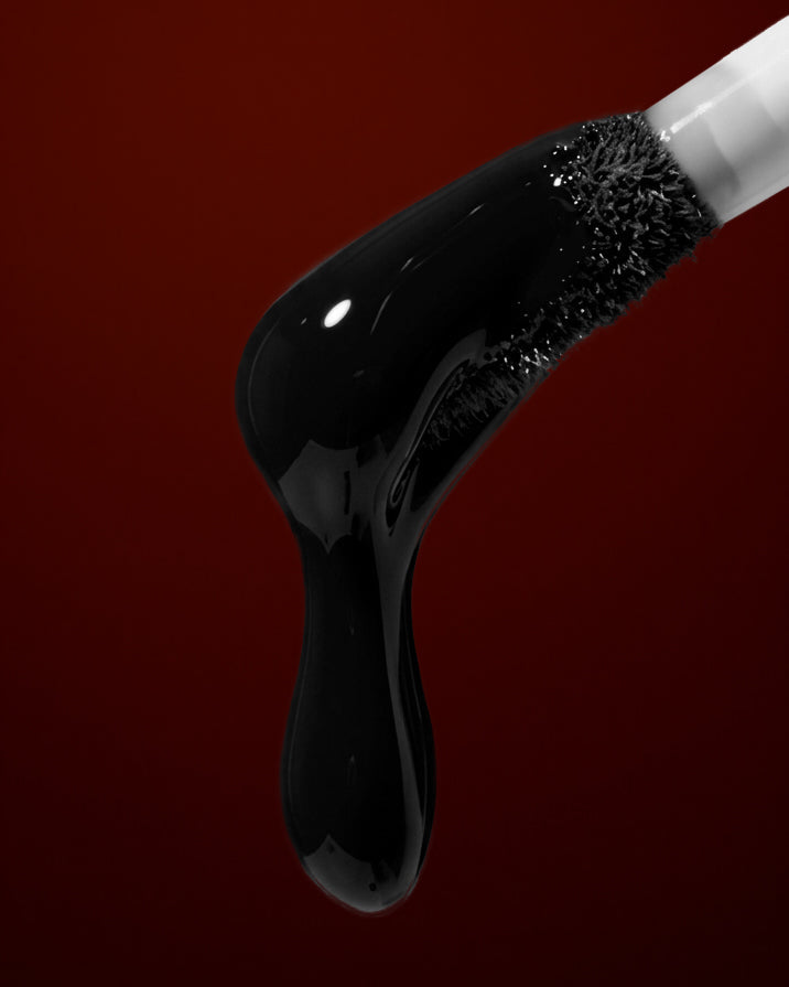 black liquid dripping on a red background